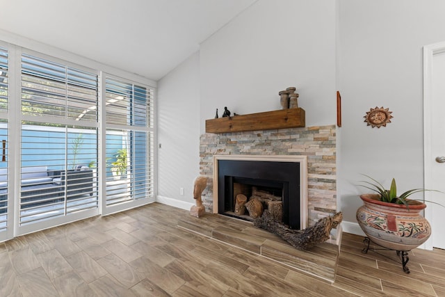 living room featuring a fireplace, light hardwood / wood-style flooring, and vaulted ceiling