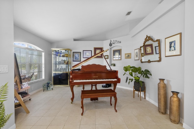 miscellaneous room featuring light tile patterned floors and vaulted ceiling