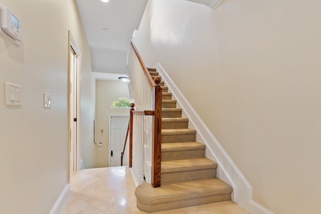 staircase featuring tile patterned flooring