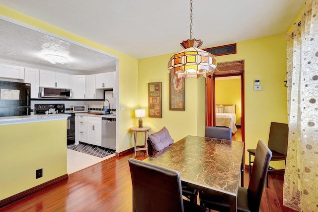 dining area with sink and dark hardwood / wood-style floors