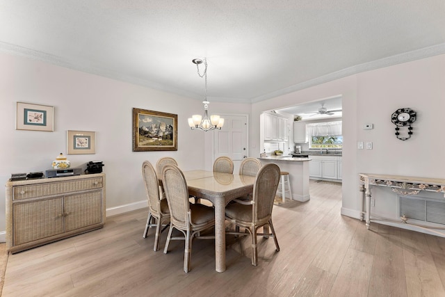 dining room with ceiling fan with notable chandelier, sink, crown molding, a textured ceiling, and light hardwood / wood-style floors