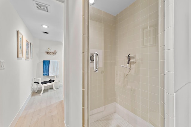 bathroom with walk in shower and hardwood / wood-style flooring