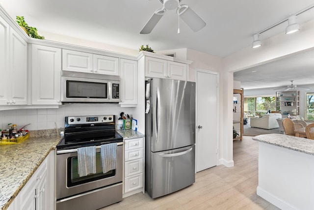 kitchen featuring backsplash, white cabinetry, stainless steel appliances, and light wood-type flooring