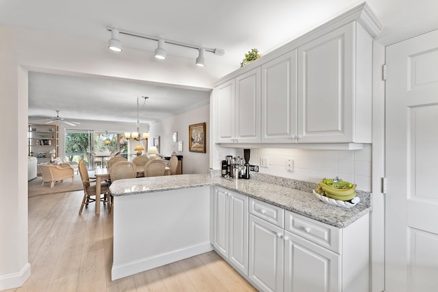 kitchen featuring light wood-type flooring, tasteful backsplash, white cabinetry, and ceiling fan