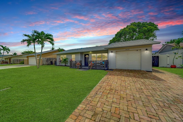 ranch-style home featuring a yard and a garage