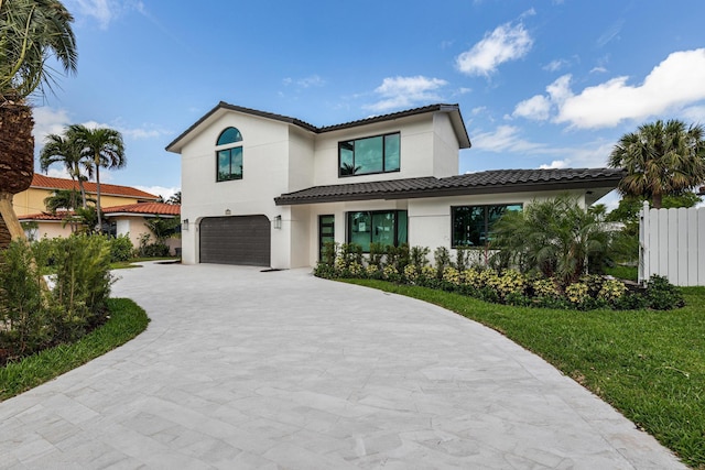 mediterranean / spanish-style house featuring a front yard and a garage