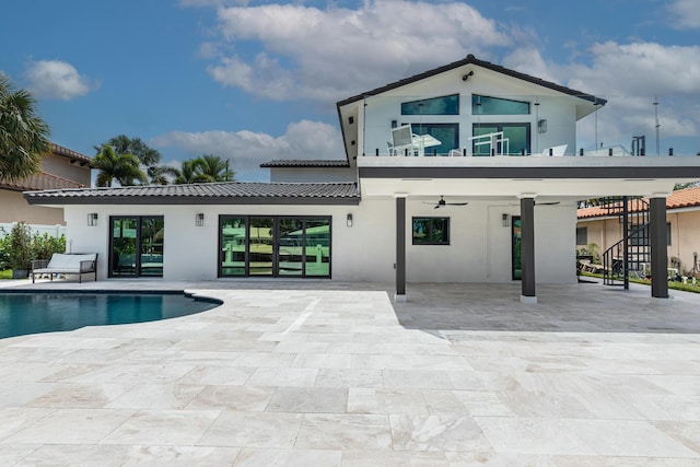 back of house with ceiling fan, a balcony, and a patio