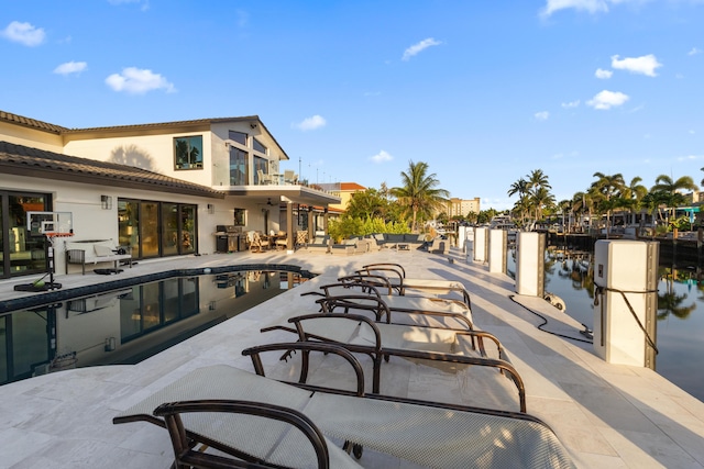 view of patio / terrace with a water view and a dock