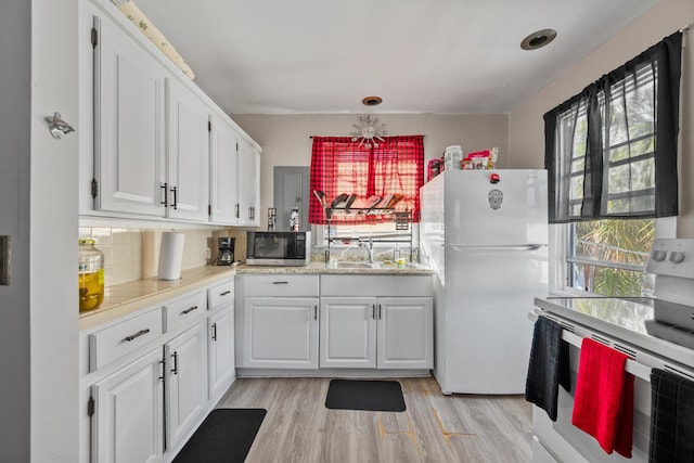 kitchen featuring range, white cabinets, light wood-type flooring, and white refrigerator