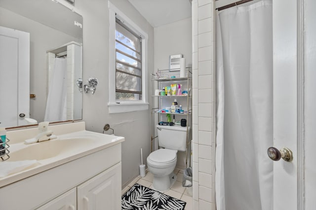 bathroom with tile patterned flooring, vanity, and toilet