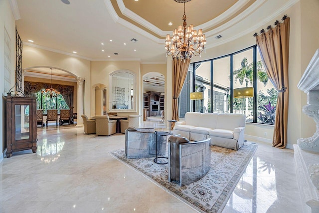 living room with a raised ceiling, ornamental molding, a high ceiling, and a chandelier