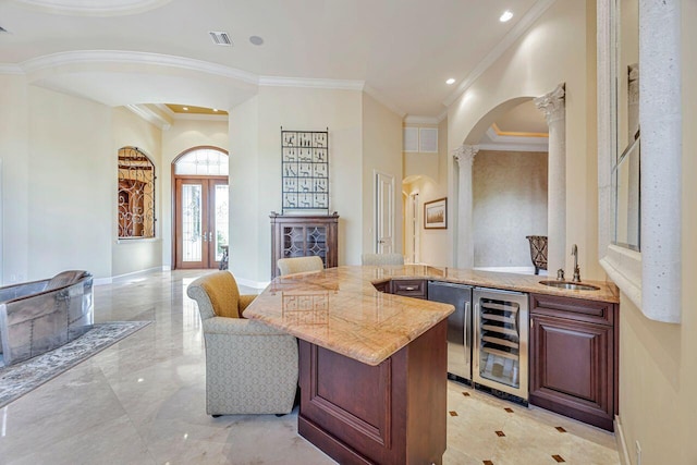 bar with light stone counters, ornate columns, ornamental molding, sink, and wine cooler