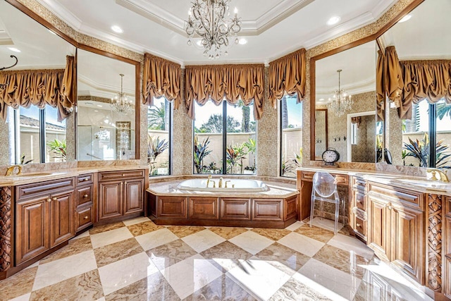 bathroom with a notable chandelier, vanity, a tub to relax in, and crown molding