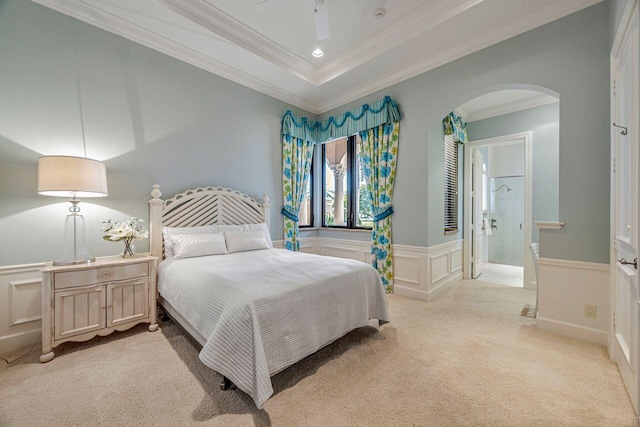 carpeted bedroom with ensuite bathroom, ceiling fan, and ornamental molding