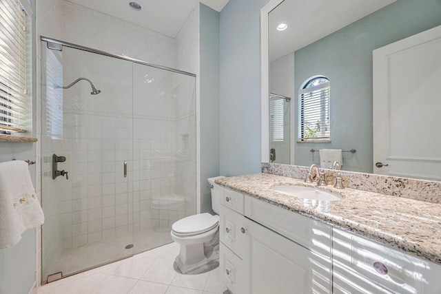 bathroom with tile patterned flooring, vanity, a shower with shower door, and toilet