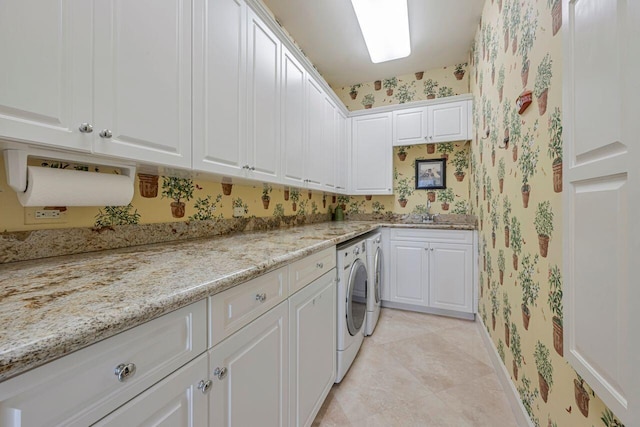 washroom with cabinets, light tile patterned floors, washer and clothes dryer, and sink