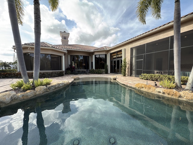 view of swimming pool featuring a sunroom