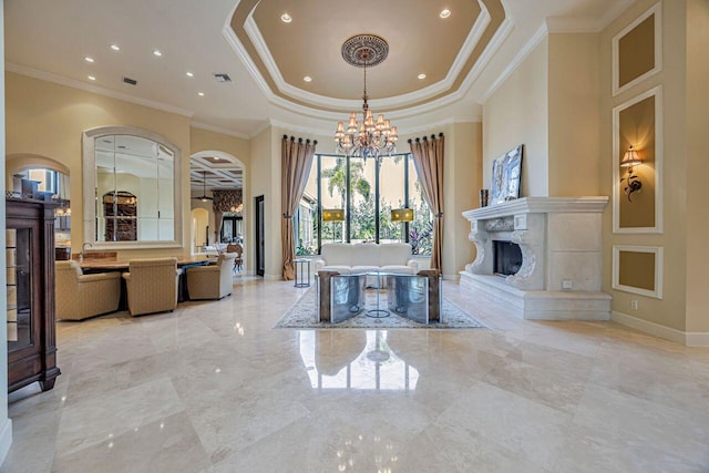 dining room with a notable chandelier, ornamental molding, a towering ceiling, and a tray ceiling