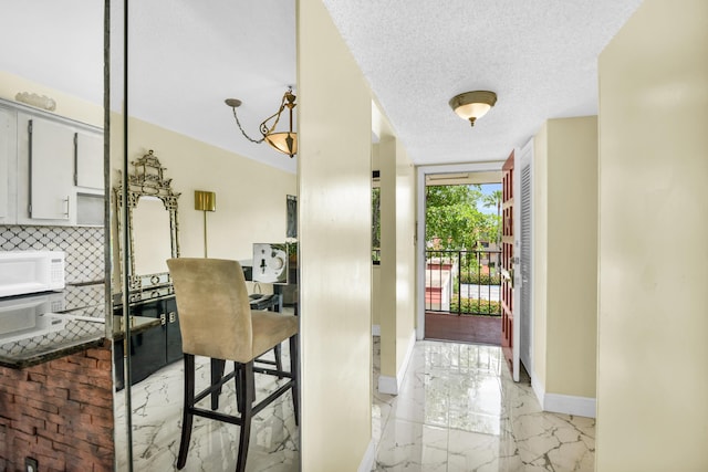 entryway featuring a textured ceiling and an inviting chandelier