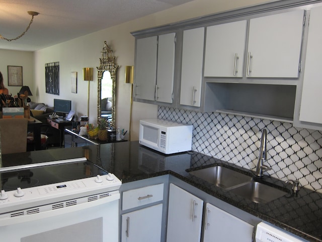 kitchen featuring decorative backsplash, white appliances, gray cabinets, and sink