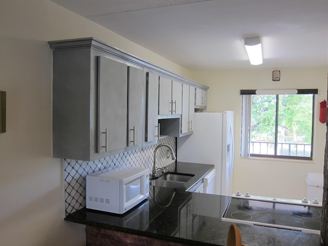 kitchen with gray cabinets, decorative backsplash, sink, and white appliances