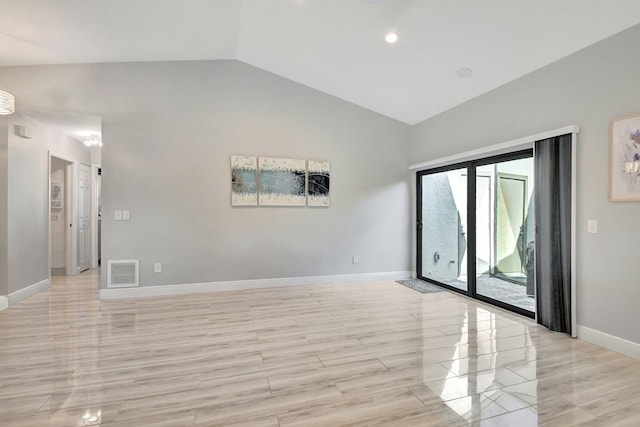 unfurnished room featuring light hardwood / wood-style floors and lofted ceiling