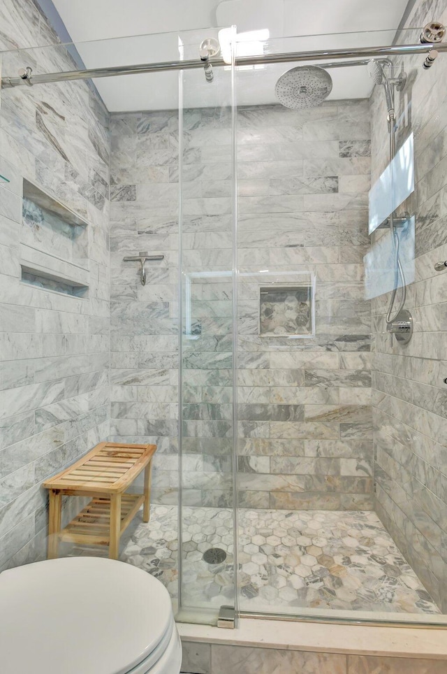 bathroom with toilet and an enclosed shower