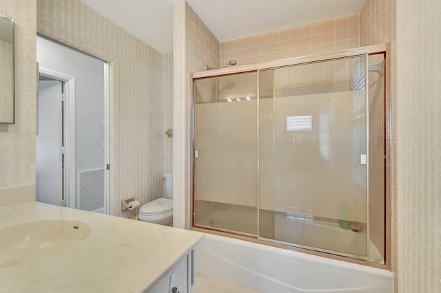 full bathroom with vanity, toilet, and shower / bath combination with glass door