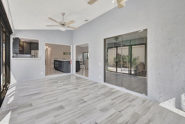 spare room with ceiling fan, light hardwood / wood-style flooring, and high vaulted ceiling