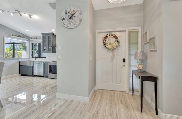 entryway featuring light hardwood / wood-style floors and vaulted ceiling