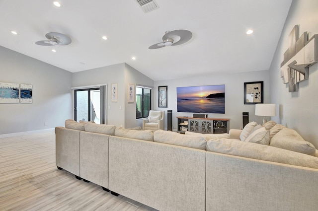 living room featuring ceiling fan, light hardwood / wood-style floors, and vaulted ceiling