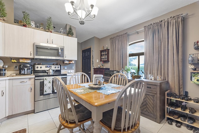 dining room with light tile patterned floors and an inviting chandelier