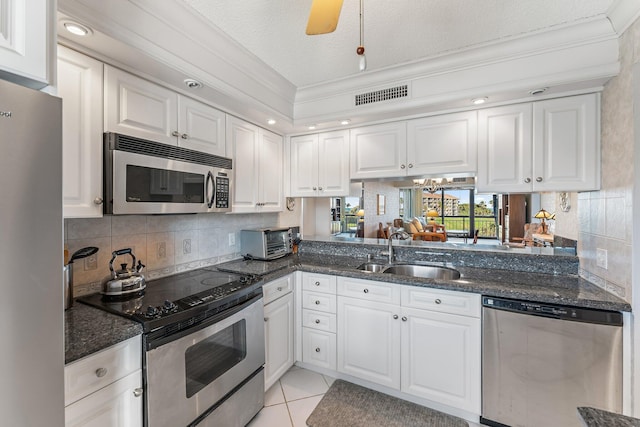 kitchen with light tile patterned flooring, sink, white cabinetry, and stainless steel appliances