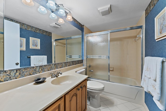 full bathroom with shower / bath combination with glass door, tile patterned flooring, vanity, and toilet