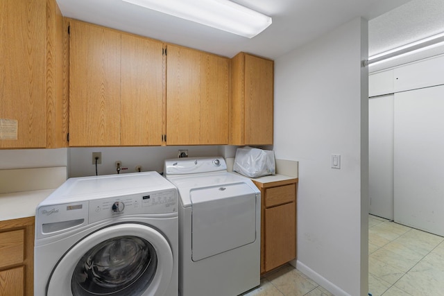 clothes washing area featuring cabinets and independent washer and dryer