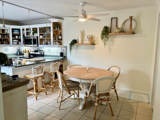 tiled dining room featuring ceiling fan and ornamental molding