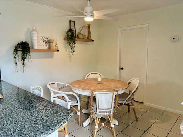 tiled dining area featuring ceiling fan and ornamental molding