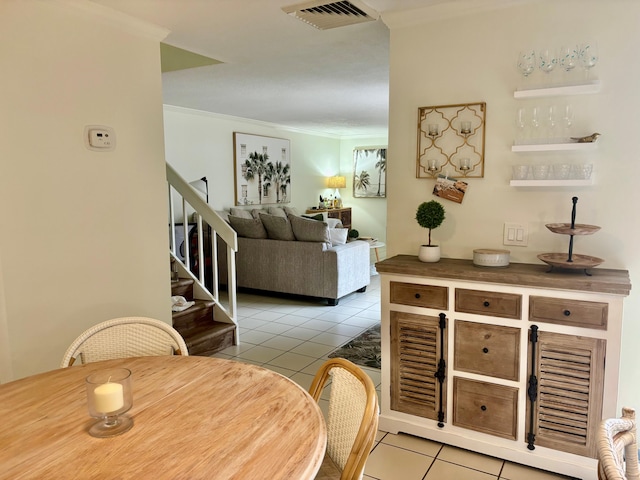 dining room featuring crown molding and light tile patterned flooring