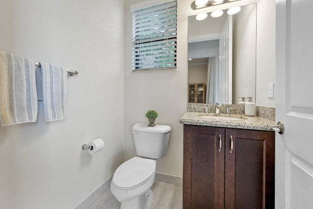 bathroom featuring tile patterned flooring, vanity, and toilet