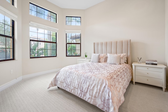 carpeted bedroom featuring a high ceiling