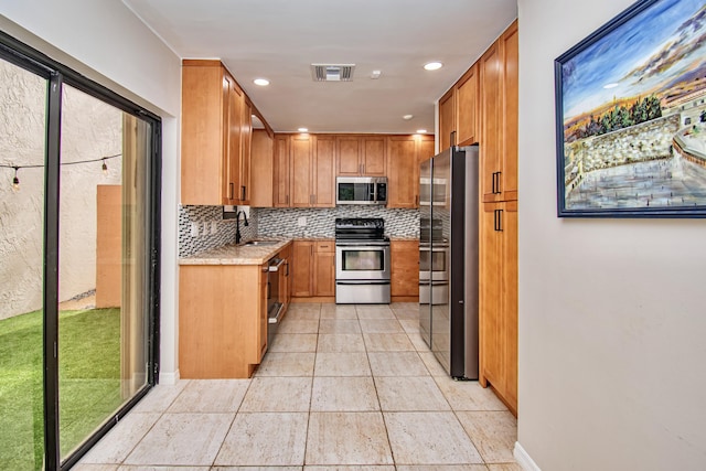 kitchen featuring backsplash, sink, and appliances with stainless steel finishes