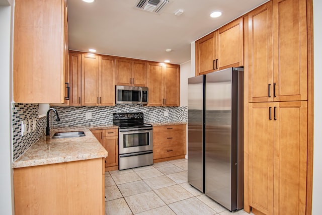 kitchen with light stone countertops, backsplash, stainless steel appliances, sink, and light tile patterned flooring