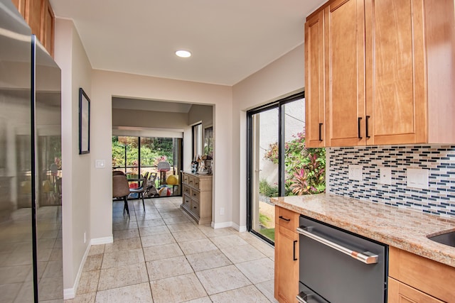 kitchen featuring decorative backsplash, stainless steel appliances, and light stone counters