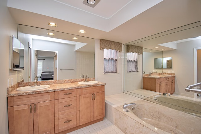 bathroom featuring tile patterned floors, tiled bath, and vanity