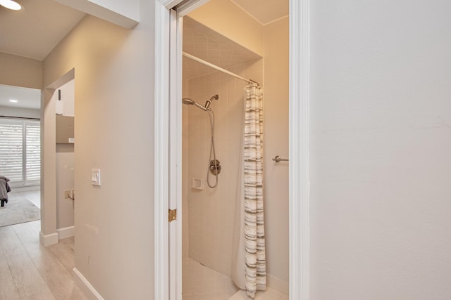 bathroom with hardwood / wood-style flooring and walk in shower