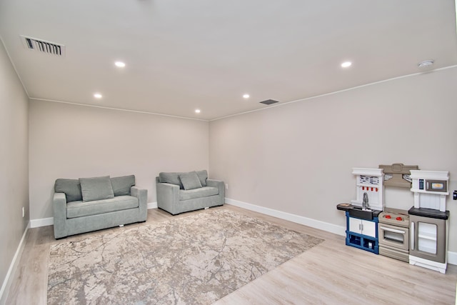 sitting room featuring light hardwood / wood-style floors and ornamental molding