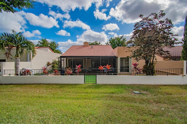 rear view of property with a sunroom and a yard