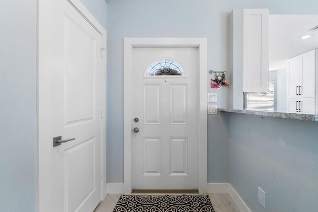 doorway featuring a textured ceiling and light tile patterned flooring