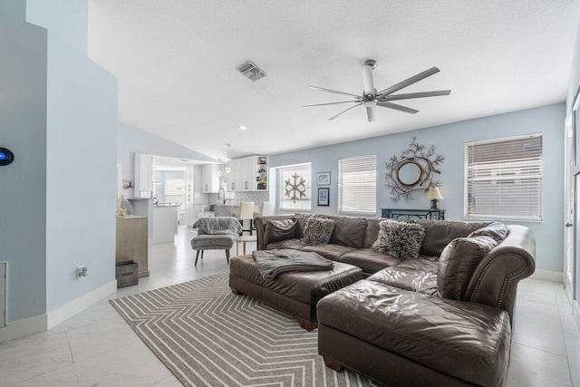 tiled living room featuring a textured ceiling, vaulted ceiling, and ceiling fan