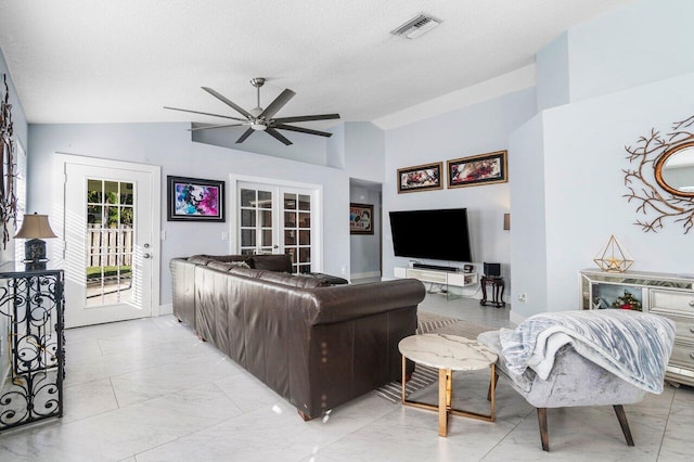 living room with french doors, a textured ceiling, vaulted ceiling, and ceiling fan